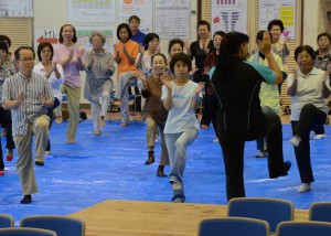 参加者たちは健康運動指導士の大城さんの指導を受けながら健康づくりのための運動について学んだ＝４日、市中央公民館