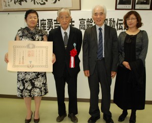 受章伝達式に出席した（写真左から）長女の美智子さん、與座さん、長男の聰さん、その妻慶子さん＝７日、宮古高校応接室