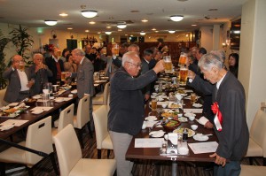 乾杯で與座氏（右手前）の受章を祝福する参加者たち＝９日夜、市平良西里のホテル