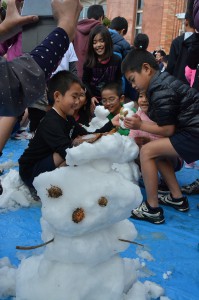 雪だるまを作って喜ぶ児童たち＝１１日、伊良部小学校の広場