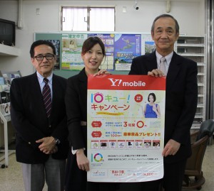 １０周年記念キャンペーンＰＲのポスターを手にする仲本社長（右）、中央は坂元さん、左は中山総務部長＝２６日、本社