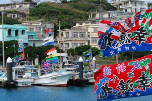 佐良浜漁港では漁船に大漁旗が掲げられ祝賀ムードに包まれていた＝１９日、佐良浜