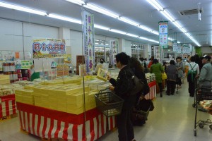 十六日祭に供える和菓子詰め合わせなどを買い求める客ら＝５日、市内の大型スーパー