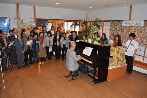 復興支援のソング「花は咲く」などを合唱する参加者ら＝１１日、伊良部のホテルてぃだの郷