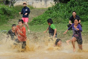 泥だらけになりながら、リレーなどを楽しむ児童ら＝１３日、宮島小学校