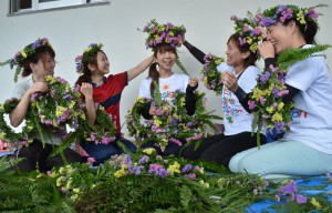 出場選手の完走を願いながら笑顔で花冠を作る保育士の皆さん＝１８日、市総合体育館