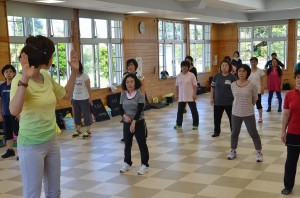 平良さんの指導を受けながら軽運動で心地よい汗を流す参加者たち＝１５日、下地保健福祉センター