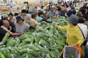 売り場には１袋５０円のゴーヤーが山積みされ、来場者は気に入った商品を買い求めていた＝８日、ＪＡファーマーズマーケットあたらす市場