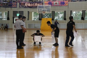 ミニバスケットボールの試合中、プレーを中断し、雨漏り箇所のタオルを交換する作業が行われた＝２３日、上野体育館