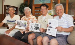 ５２年ぶりに宮古島を訪れ当時の記念写真などを手にする３人。左から２人目は当時、３人が昼食を取ったり記念撮影したりした思い出の場所「野村レストラン（当時）」の野村安潤さん＝市内ホテル