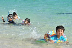 強い日差しの受け、元気いっぱいに海で遊ぶ子どもたち＝３１日、与那覇前浜ビーチ