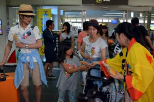 東京羽田空港から訪れた観光客らに冷たいマンゴーをプレゼントして祭りの開催を告知した＝１８日、宮古空港