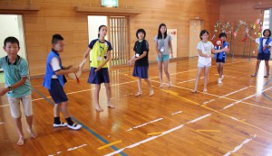 クイチャーを踊る板倉区と城辺の児童たち＝２１日、城辺小学校体育館
