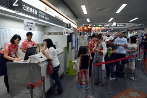 空席待ちの整理券を発行するカウンターに並ぶ乗客ら。台風の接近で足止めを余儀なくされた＝７日、宮古空港