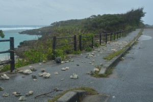 激しい波の影響で浜から打ち上げられた石が散乱していた歩道＝２４日、下地島
