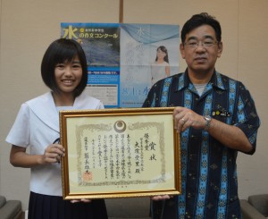 「中学生水の作文コンクール」の優秀賞で、安慶名統括監（右）から県知事表彰された大濱さん＝３日、県庁