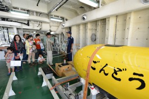 自律型潜水調査機器「ごんどう」の説明を受ける見学者ら＝１４日、「拓洋」船内