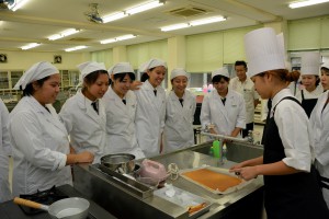 パティシエの重本さん（右）の指導を受けながらショートケーキの作り方を学ぶ生徒たち＝２７日、宮古工業高校
