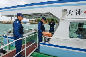「スマヌかりゆす」の浮き輪など安全設備を点検する海保職員＝２８日、島尻漁港