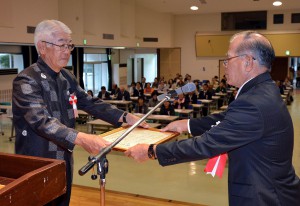 饒平名会長（右）が社会福祉の発展に貢献した５０人を表彰した＝２５日、市中央公民館