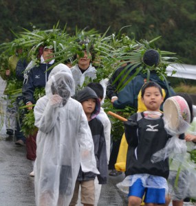 子供パーントゥを先頭に集落内を払い清める参加者ら＝１日、上野地区野原