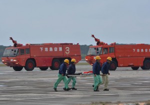 負傷者を担架で搬送する参加者ら＝２４日、下地島空港