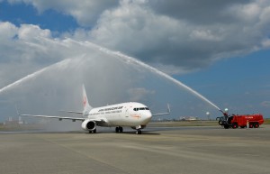 歓迎の放水アーチに迎えられ、空港ターミナルに向かうＪＴＡの新機種Ｂ７３７－８００＝１０日、宮古空港