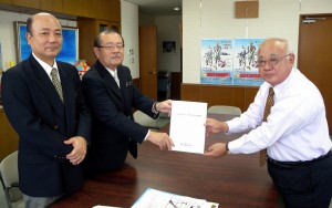 下地市長に天然ガス資源利活用推進計画書を手渡す長濱委員長（左から２人目）ら＝３１日、市役所平良庁舎