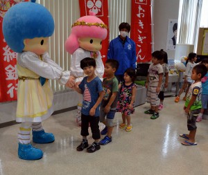 沖銀のイメージキャラクター「キキ＆ララ」と握手をする子どもたち＝１５日、沖銀宮古支店