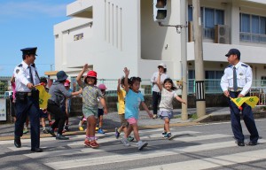 安全を確認して横断歩道を渡る児童たち＝12日、狩俣小校門前