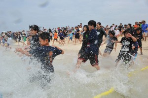 合図と共に一斉に海に入る参加者たち＝３日、与那覇前浜ビーチ
