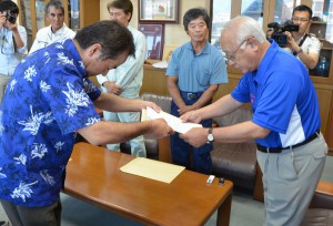 島尻会長（手前左）が要請書と決議書を下地市長に手渡した＝12日、市役所平良庁舎