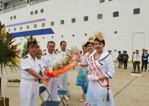 ミス宮古島（写真右３人）から花束を贈られた（左から）由良船長、藤村機関長と阿部ホテルマネジャー＝１５日、下崎埠頭