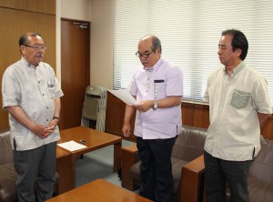 長濱副市長（左）に事業完了を報告する下地会頭（中央）＝１０日、市役所平良庁舎