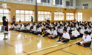 津嘉山さんの話を聞く生徒たち＝１７日、平良中学校体育館
