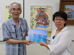 宮國教育長（左）にカレンダーを手渡す砂川理事＝２９日、市役所城辺庁舎