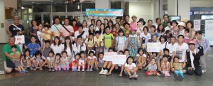 今年の宮古島保養プロジェクトのスタートを祝って記念撮影する福島からの家族と宮古島の受け入れメンバーたち＝２６日、宮古空港