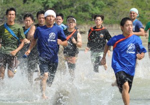潮が満ち始めた干潟で力走する参加者ら＝１７日、与那覇サニツ浜