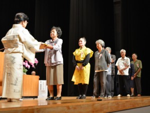 花城支部長（左）が表彰状を手渡した＝２１日、マティダ市民劇場