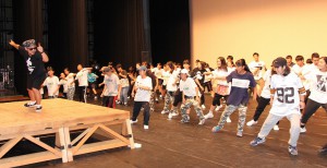 インストラクターの手本に合わせ最終日のオープニングで披露するダンスの練習をする参加者たち＝２３日、マティダ市民劇場