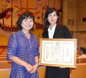 記念イベントで表彰された大城会長（右）とシンポジウムに出席した謝敷さん＝１７日、宜野湾市の沖縄コンベンションセンター