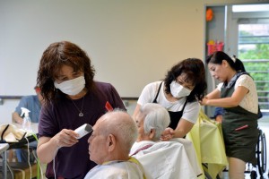 利用者の散髪をする美容師の皆さん＝６日、栄寿園