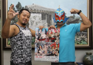 宮古島開催のポスターを手にポーズを取るグルクンマスクこと石倉さん（右）と佐々木さん＝６日、本社