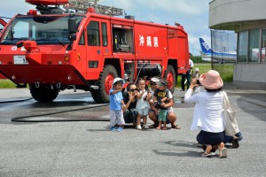 消防車をバックに記念撮影。普段入れない空港内の消防施設を見学した＝２４日、宮古空港