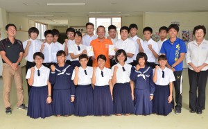 狩俣会長（後列中央）から激励金が卓球部と女子駅伝部に贈呈された＝１５日、宮古高校
