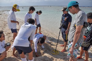 調査を体験し、穴を掘り起こす多良間中の生徒ら＝１５日、多良間村高田海岸
