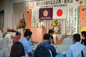 創立４０周年記念式典であいさつする池村会長（奥）＝１８日、市内のホテル