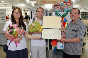 長濱副市長（右）から婚姻届受理証明書を受け取る林さん（中央）と黄さん＝２２日、市役所平良庁舎