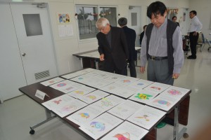 子供たちの感性豊かな作品を審査する仲間会長（右）ら＝２日、市伊良部公民館