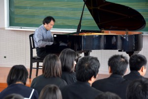 クラシックの名曲を演奏する福田直樹さん。生徒の視線をくぎ付けにした＝２６日、鏡原中学校